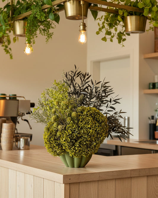 Green floral arrangement in a vase on a table