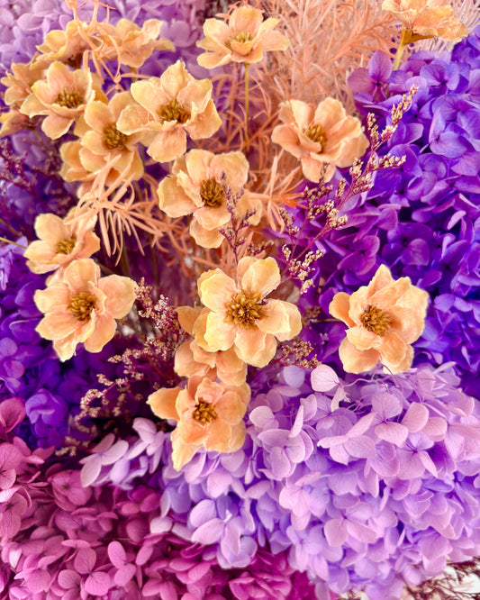 Close-up of yellow flowers and purple hydrangeas with a blurred background