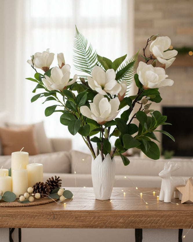 Bouquet of white magnolia flowers with green leaves in a white vase