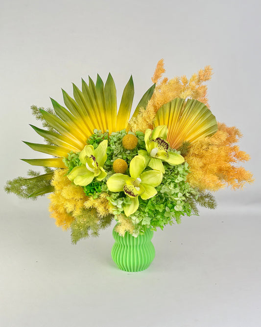 Bouquet of dried yellow and green flowers in a green vase on a light gray background