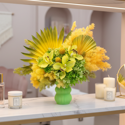 Decorative floral arrangement with yellow and green flowers in a green vase on a table.
