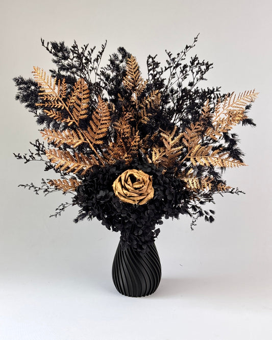 Black vase with dried flowers on a white and gold pedestal 