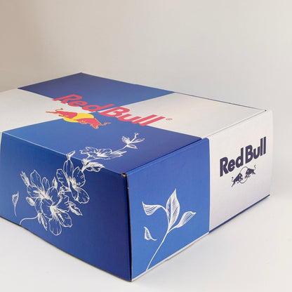 Red Bull branded box with floral design on a white background