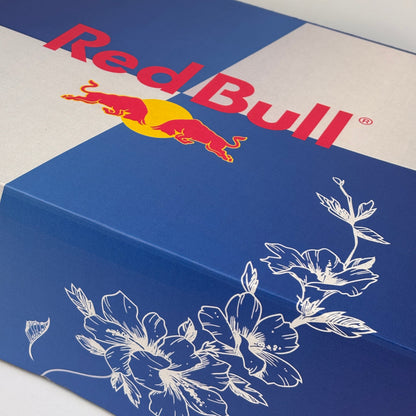 Red Bull logo on a blue and white background with floral design