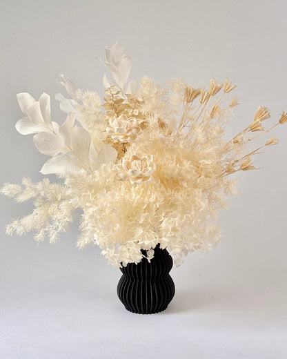 Black vase with dried flowers on a white background