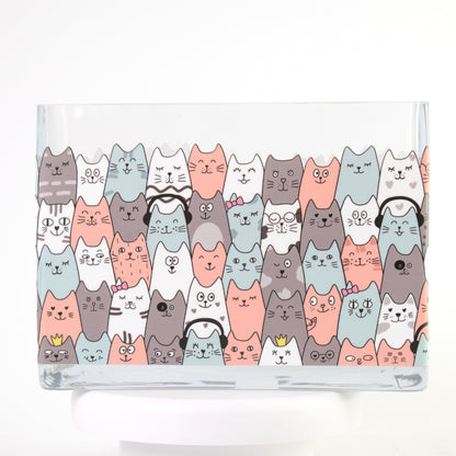 Clear glass vase with a colourful pattern of illustrated cats in coral, teal, white, and grey.