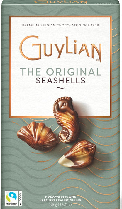 Front of a Guylian chocolate box featuring 'The Original Seashells' product. The packaging is sage green with a cream central panel, gold and gray text, and illustrations of three chocolate seashells on the front.