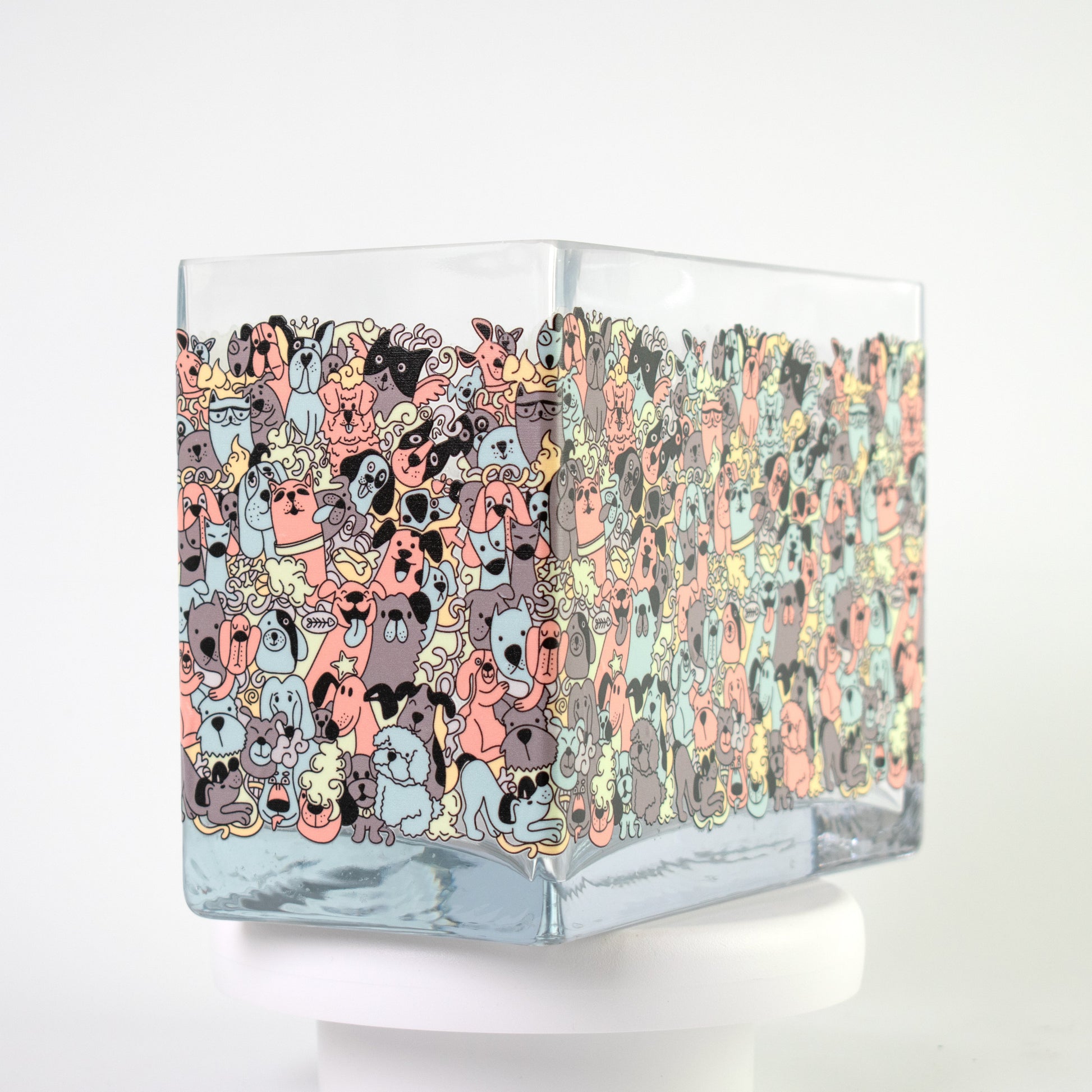 Clear glass vase with a colourful cartoon dog pattern in coral, teal, grey, and beige tones — size 20x10x15 cmH.