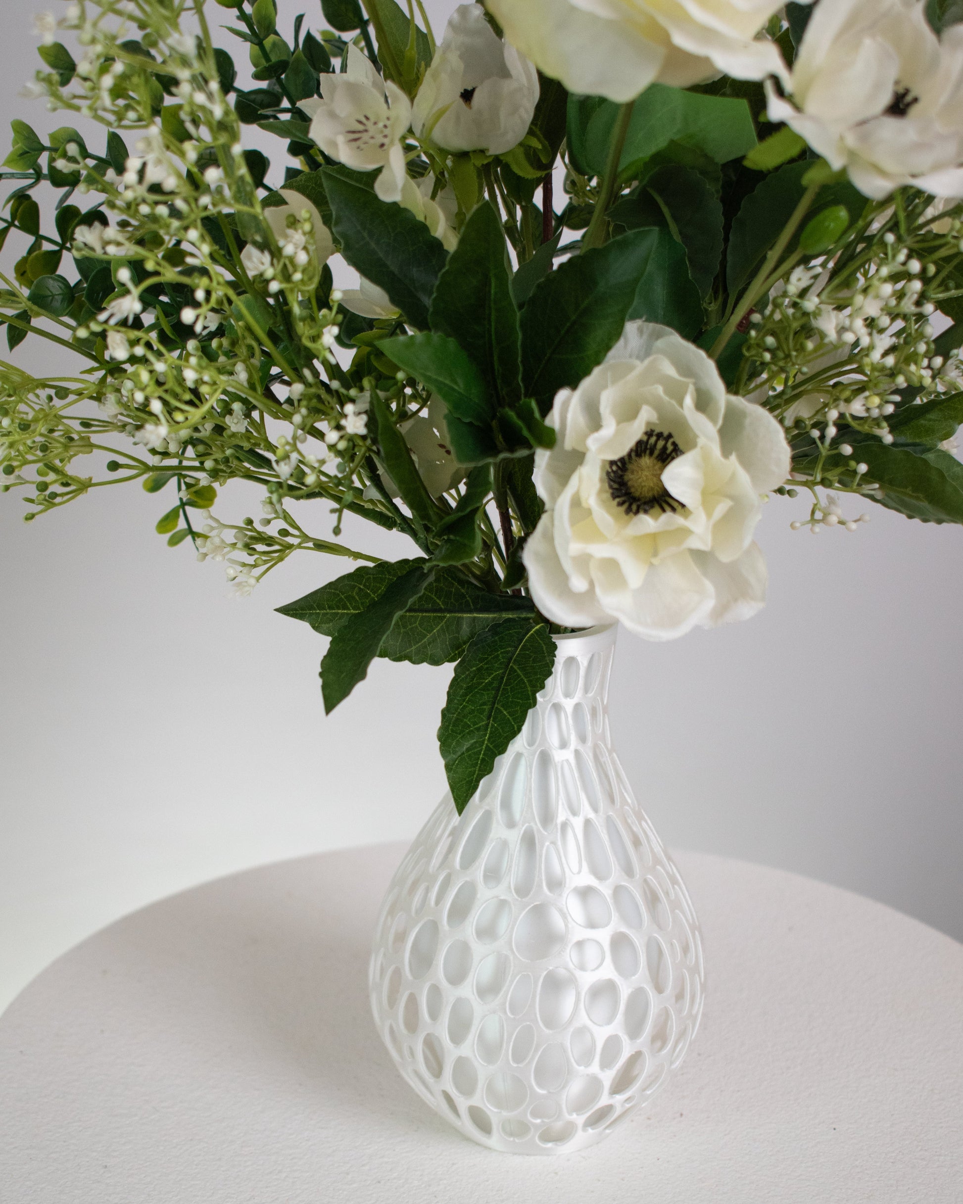 Flowers presented in a modern honeycomb-inspired white vase, this piece blends contemporary design with natural beauty. 
