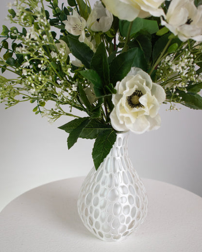 Flowers presented in a modern honeycomb-inspired white vase, this piece blends contemporary design with natural beauty. 