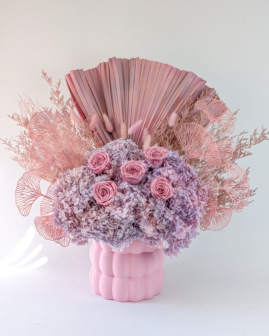 Pink floral arrangement with decorative elements on a white background