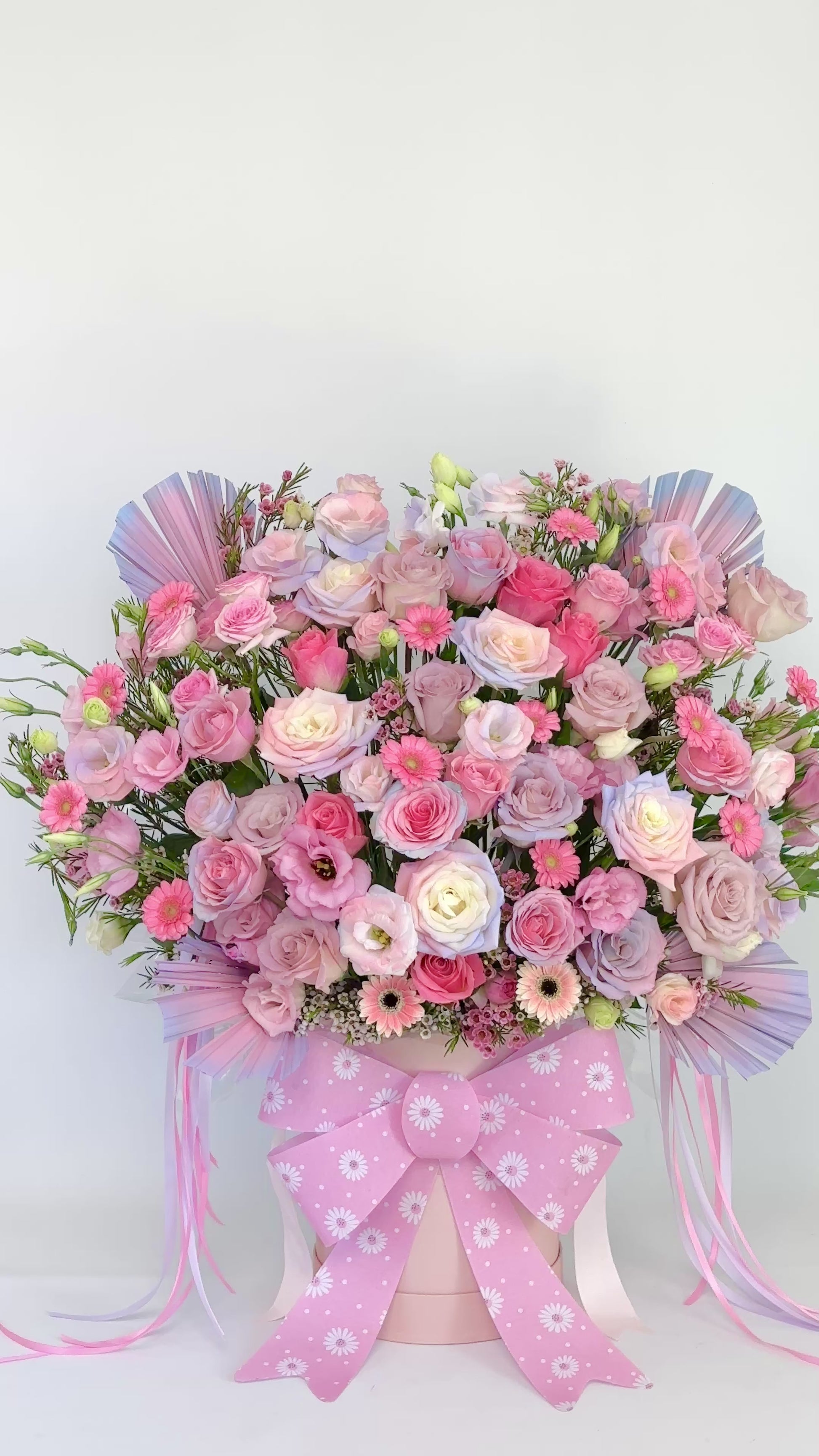 Gift flower box arrangement with roses and gerberas, finished with a pink patterned ribbon