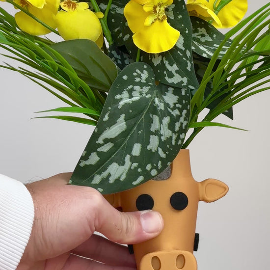 Yellow and green flowers in a giraffe-shaped vase