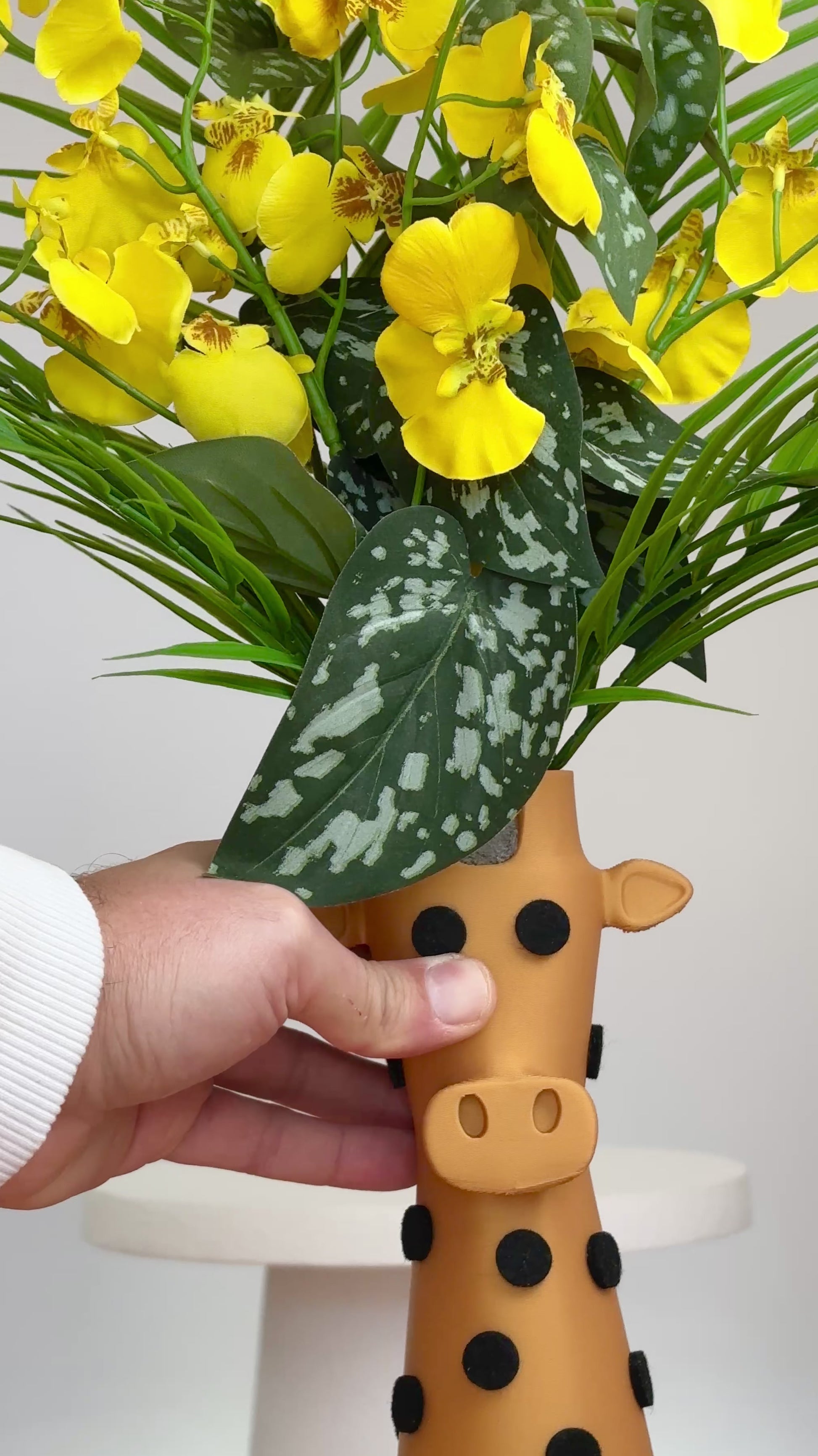 Yellow and green flowers in a giraffe-shaped vase