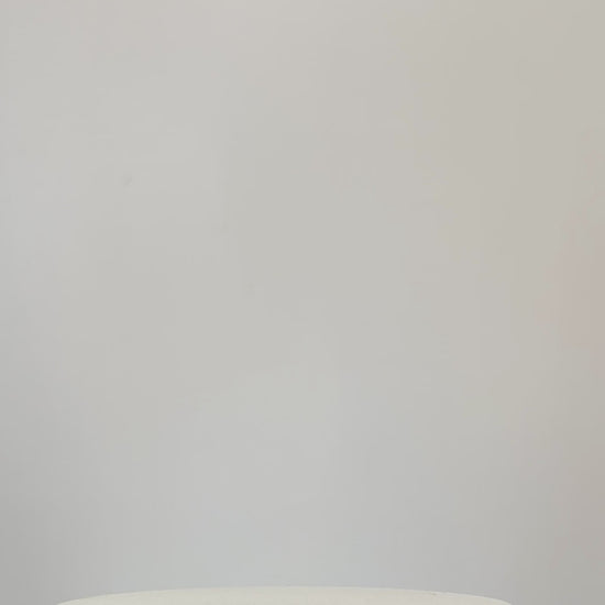 Rustic artificial floral arrangement with natural branches and light green leaves arranged in a dark brown cowboy boot-shaped vase, styled as a modern rustic décor accent.