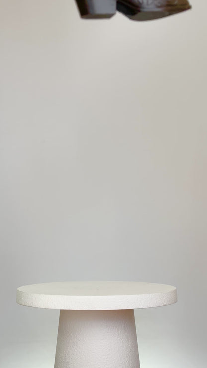 Rustic artificial floral arrangement with natural branches and light green leaves arranged in a dark brown cowboy boot-shaped vase, styled as a modern rustic décor accent.