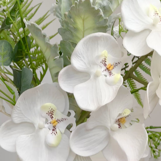 Luxury artificial orchid arrangement with white blooms and greenery for home or office décor.
