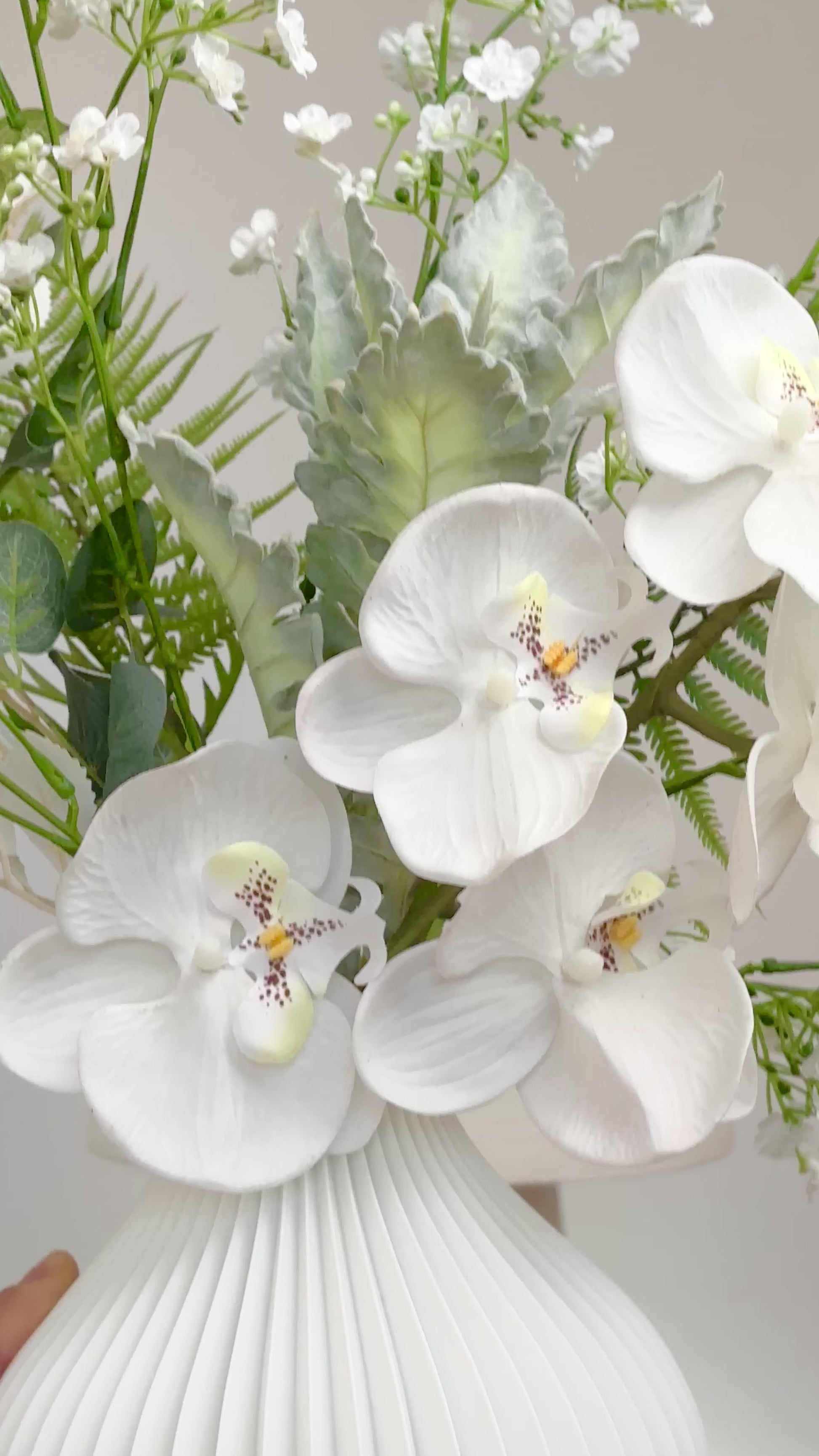 Luxury artificial orchid arrangement with white blooms and greenery for home or office décor.