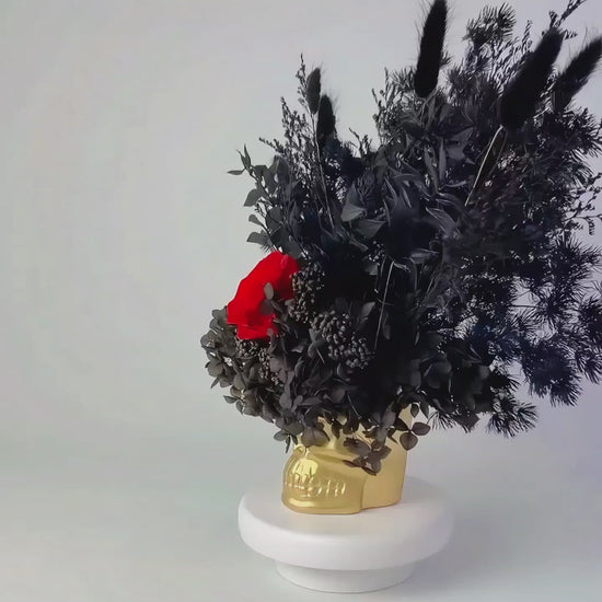 black and red dried flower in golden skull