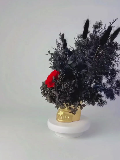 black and red dried flower in golden skull