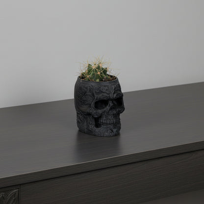 Skull-shaped planter with a cactus on a white background