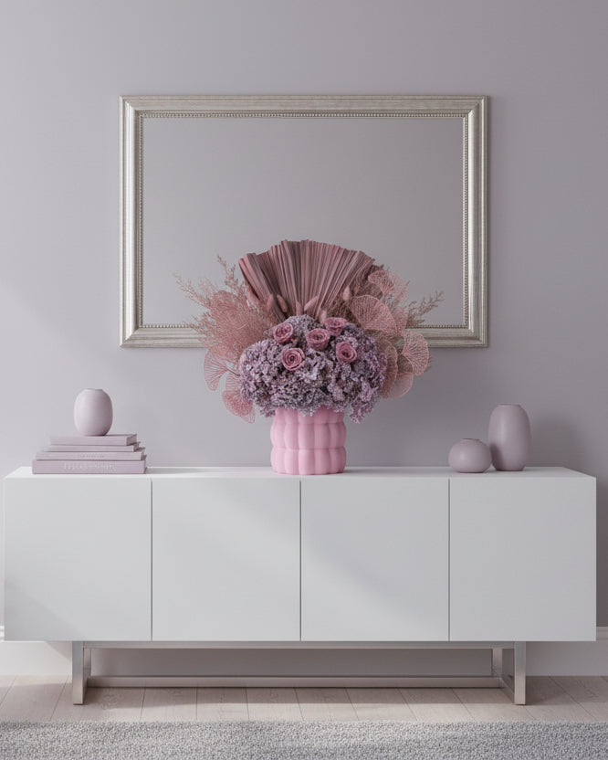 Pink floral arrangement with decorative elements in a pink vase on a white background